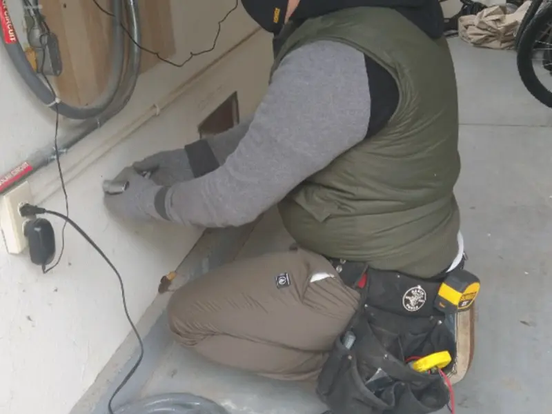 Electrician performing outlet wiring in a Tarpon Springs garage